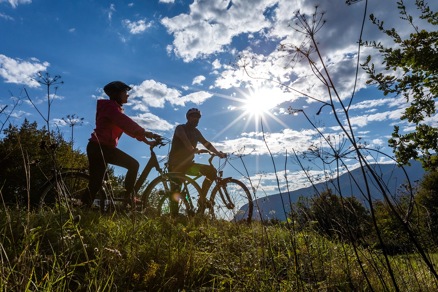 Due ciclisti sui colli con il sole alle spalle.